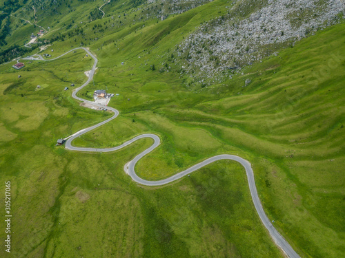 Aerial view of asphalt road, roadway with meadow in Passo Giau, winding road in mountain valley in summer, Dolomites, Italy. © Sen