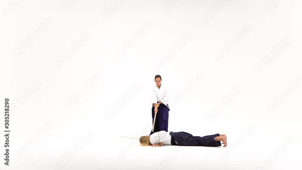 Man and woman practicing aikido using bokken. Isolated on white.