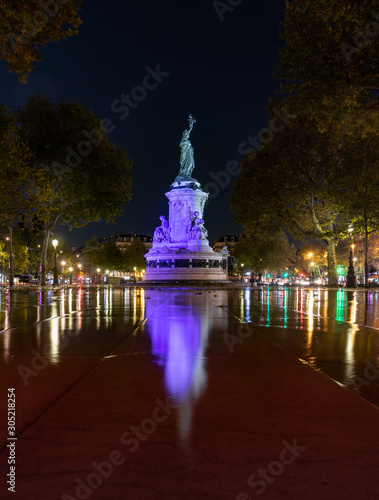 Paris by night the monument to the Republic with the symbolic statue of Marianna, in Place de la Republique water reflection bleu color