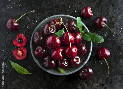 Fotografering Composition of sweet cherries on a dark background with water drops top view