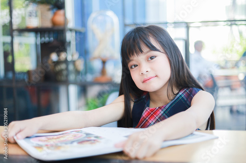 Asian little girl reading book smile and happy face