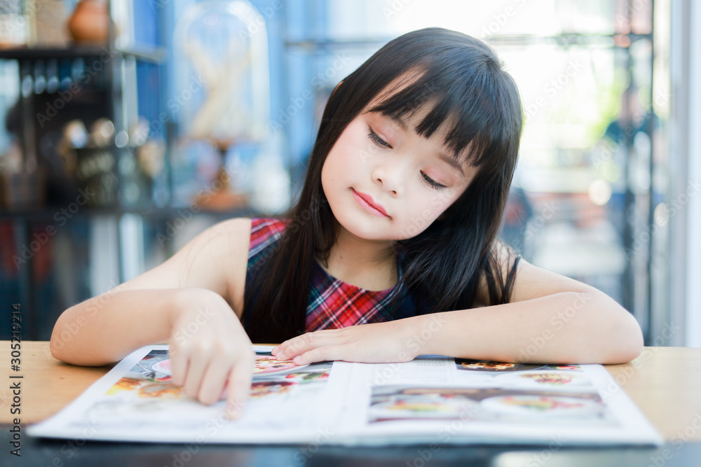 Asian little girl reading book smile and happy face Asian little girl reading book smile and happy face