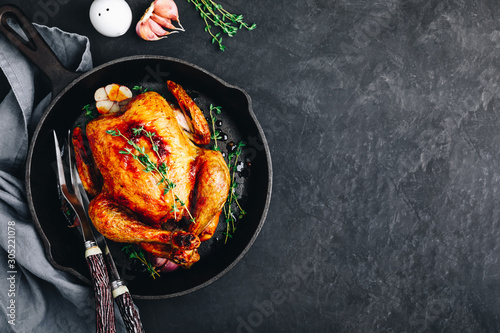 Grilled fried roasted whole Chicken in cast iron pan