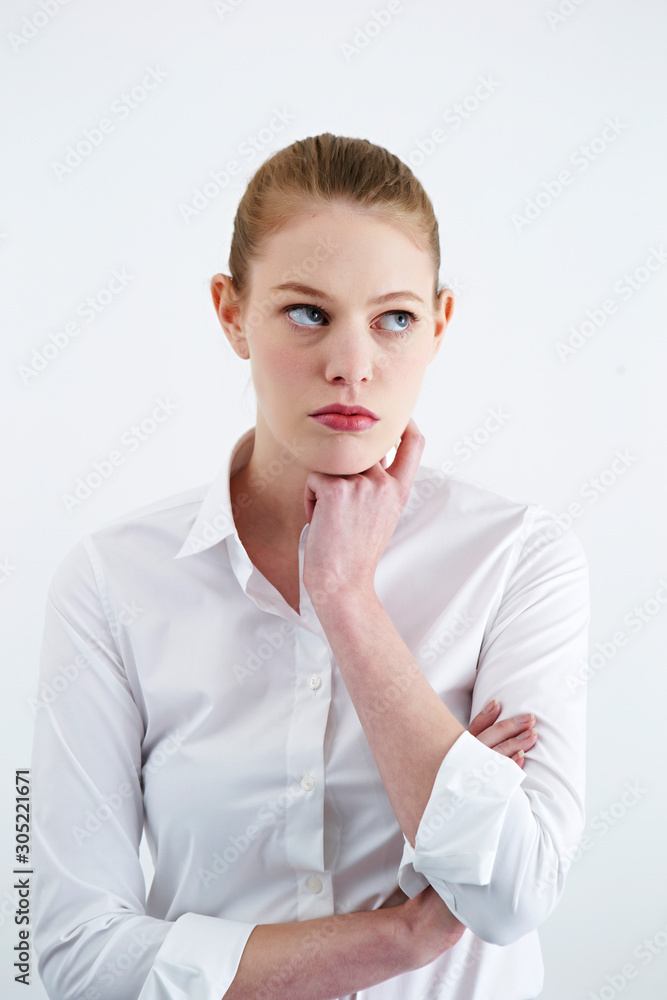 Caucasian woman in white shirt, thinking pose Caucasian woman in white shirt, thinking pose