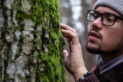 Man in a forest near a tree 