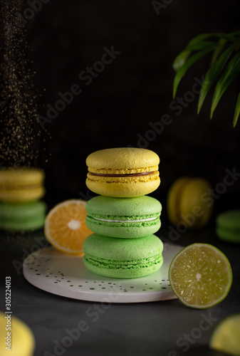 assorted colorful macarons with golden powder (kandurin). french dessert. dark background photo