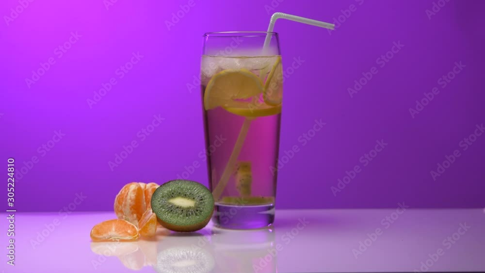 Glass with a drink on a pink background ( Vapor, lemon, kiwi, orange, ice) Glass with a drink on a pink background ( Vapor, lemon, kiwi, orange, ice)