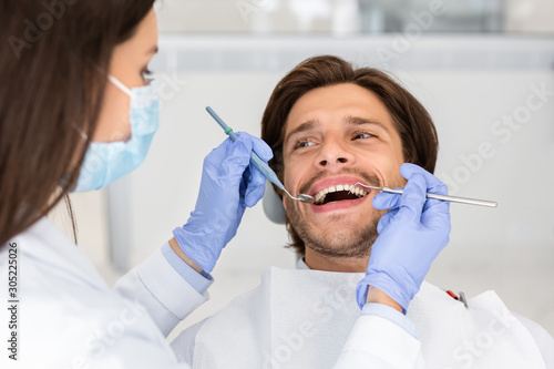 Male patient of dental clinic looking at dentist with trust