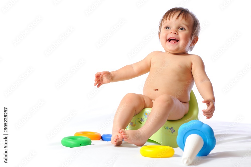 Baby sits on potty and plays toy