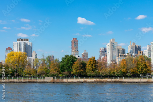 Skyline of Roosevelt Island with the Upper East Side of Manhattan in New York City in the background with Colorful Trees during Autumn © James