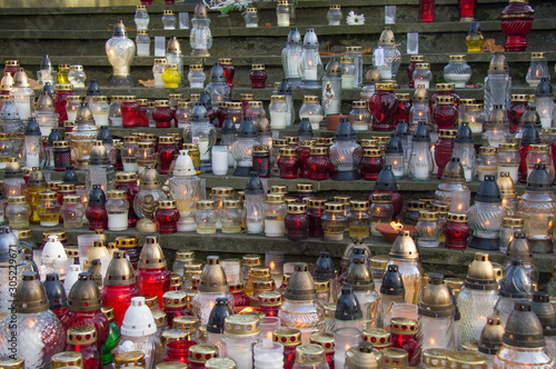 Monument and candles in the cemetery. All Saints Day in Poland. A lot of funeral candles.