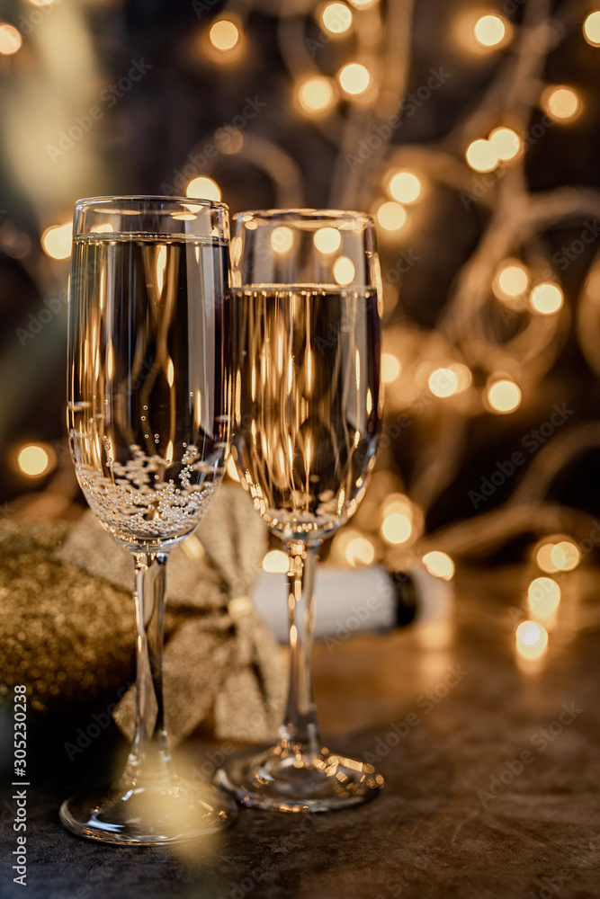 two champagne flute with shiny bottle on dark background with lights two champagne flute with shiny bottle on dark background with lights