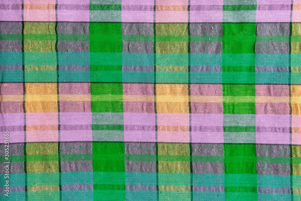 Bright fabric in a multi-colored cage. Checkered cotton fabric as background Bright fabric in a multi-colored cage. Checkered cotton fabric as background
