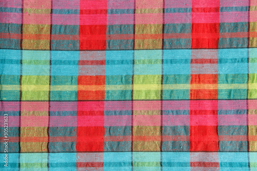 Bright fabric in a multi-colored cage. Checkered cotton fabric as background