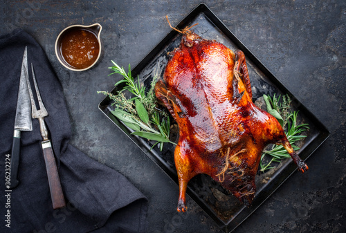 Photographie Traditional roasted stuffed Christmas Peking duck with herbs and sauce as top vi