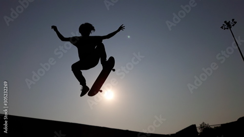 silhouette of man jumping on a background of blue sky