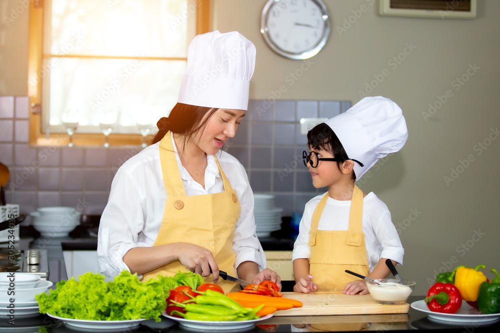 Happy family Asian woman young mother with son boy cooking healthy salad for the first time. first lesson and healthy lifestyle concept. Happy family Asian woman young mother with son boy cooking healthy salad for the first time. first lesson and healthy lifestyle concept.