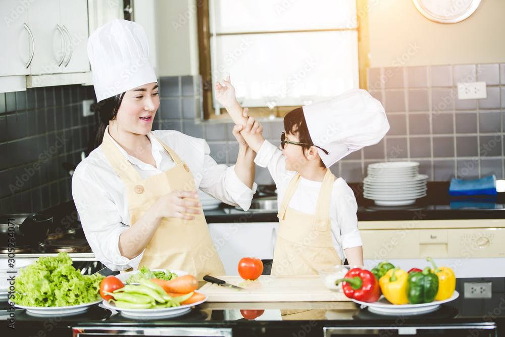 Happy family Asian woman young mother with son boy cooking healthy salad for the first time. first lesson and healthy lifestyle concept. Happy family Asian woman young mother with son boy cooking healthy salad for the first time. first lesson and healthy lifestyle concept.
