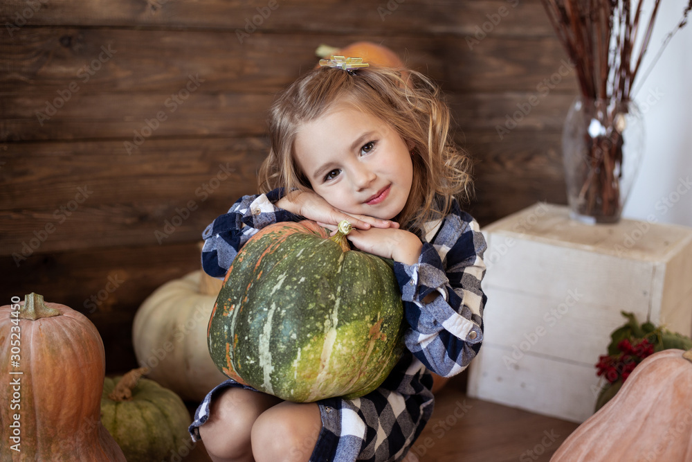 Fototapeta premium cute girl holding a pumpkin, autumn background
