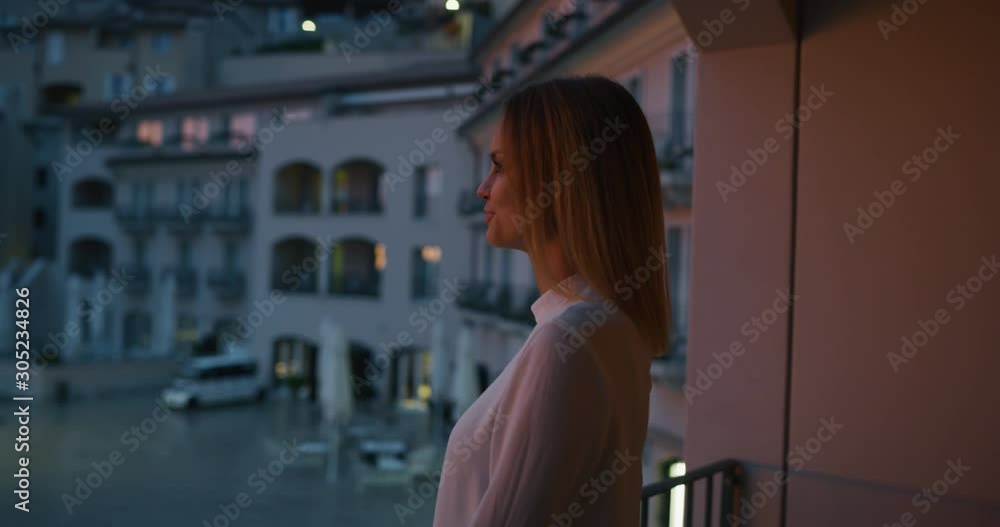 An young couple is enjoying time together on a terrace of a hotel room during their romantic vacation with panoramic view on a sea with yachts at sunset. An young couple is enjoying time together on a terrace of a hotel room during their romantic vacation with panoramic view on a sea with yachts at sunset.