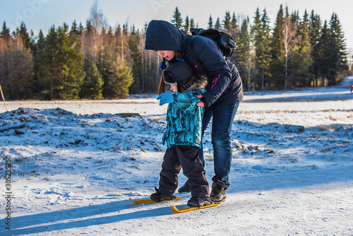 Mother teaches young son to ski