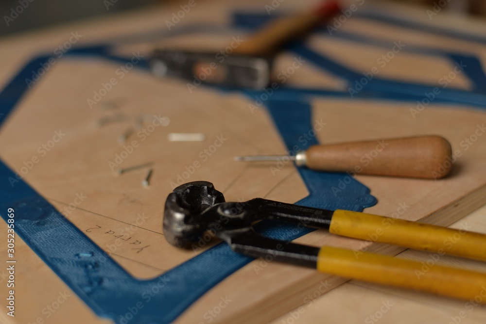 Pliers, hammer, awl, pencil, nails and patterns of blue plastic on plywood boards Pliers, hammer, awl, pencil, nails and patterns of blue plastic on plywood boards