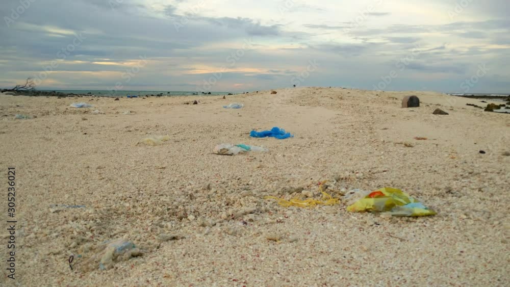 Ocean waves roll in on the peaceful rocky shore on tropical island. plastic waste. Ocean waves roll in on the peaceful rocky shore on tropical island. plastic waste.
