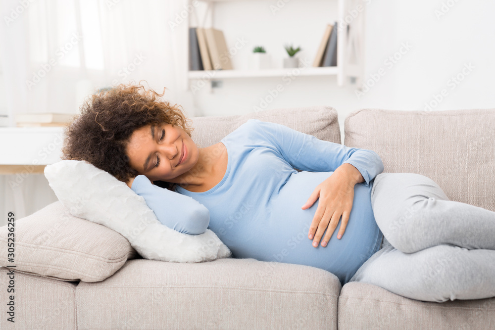 Happy pregnant woman napping on sofa, having sweet day dream Happy pregnant woman napping on sofa, having sweet day dream