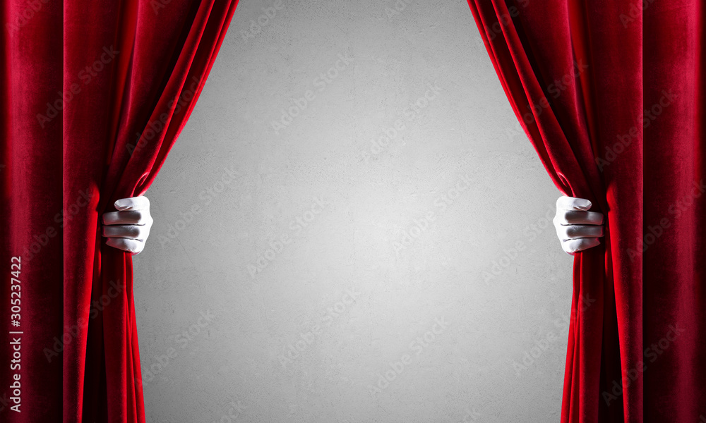 Concrete wall behind drapery curtain and hand opening it