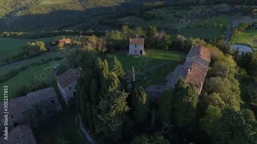 4k aerial  drone backward flight footage over the Tuscany countryside hills and the small ancien village of Gello near Volterra. photo