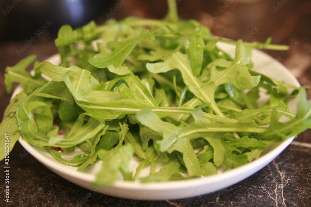 plate with fresh green arugula plate with fresh green arugula