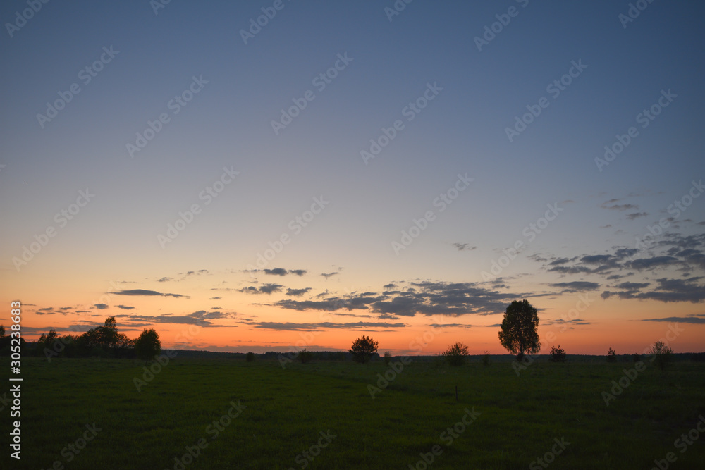 Summer sunset over a mown field