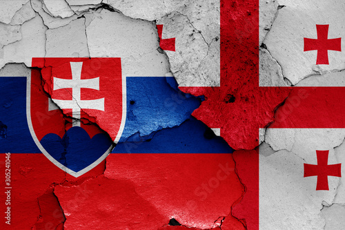 flags of Slovakia and Georgia painted on cracked wall
