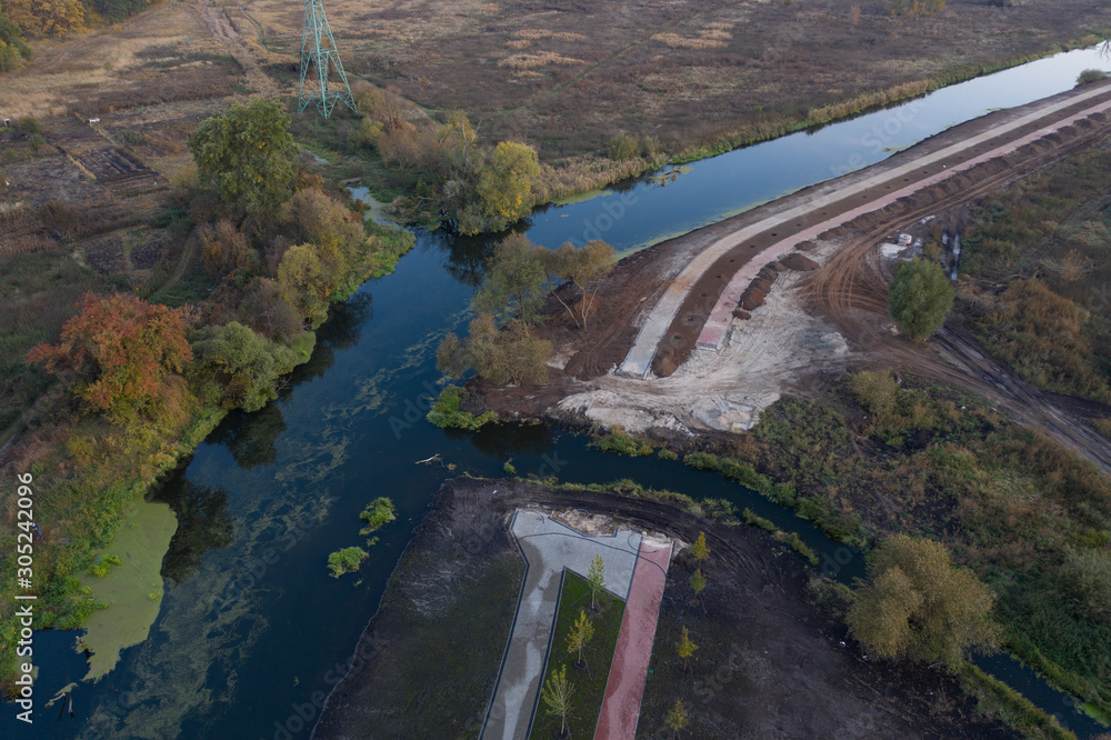 Fototapeta premium Environmental damage. Construction of a park on the river bank.
