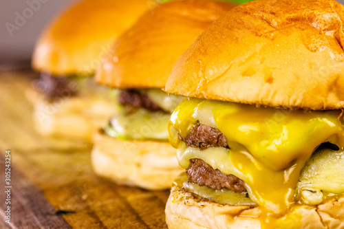 Três hamburgueres. Um com uma carne, um duplo e um triplo cheese burguer em close up photo