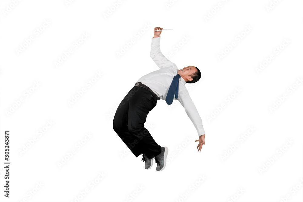 Businessman looking at digital tablet computer while doing some acrobatic moves isolated over white background