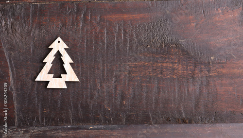 A small christmas tree decoration on an old wooden background. Flat lay, top view, copy space.