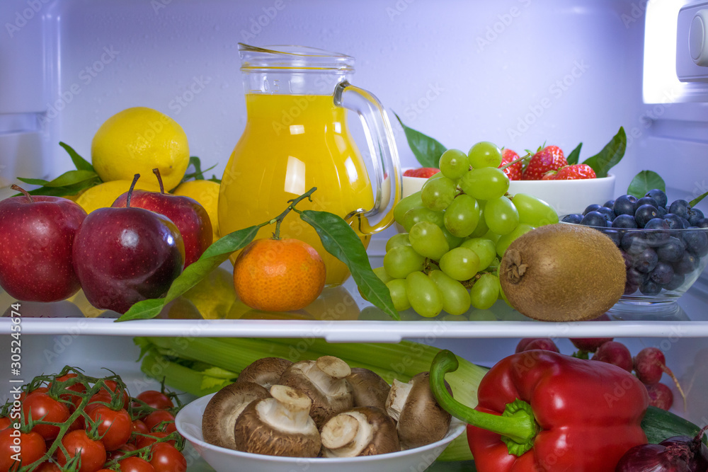 Food photography of a clean fridge filled with vegan foods such as fruits vegetables, juices and plant milk Food photography of a clean fridge filled with vegan foods such as fruits vegetables, juices and plant milk