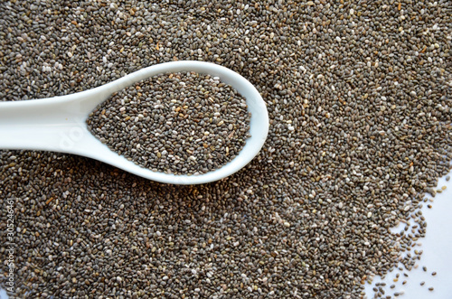 chia seeds on a white plate and a spoon with chia seeds