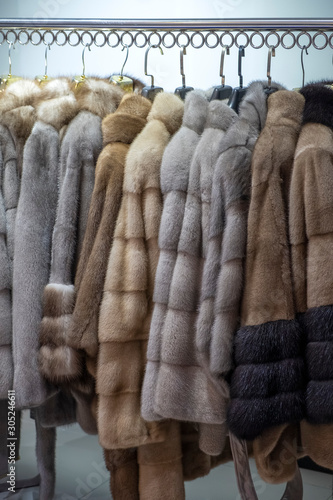 Mink coats on hangers in store. Women's fashion