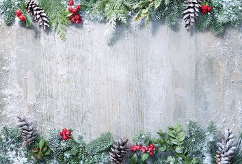 Christmas and New Year background with fir branches and snowfall on wooden white board