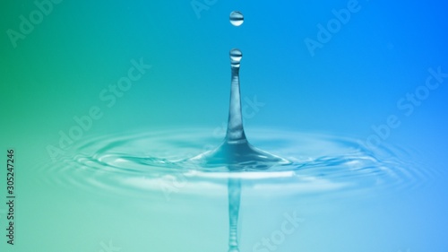 Water drop surface collision with circular puddle effect in blue and green