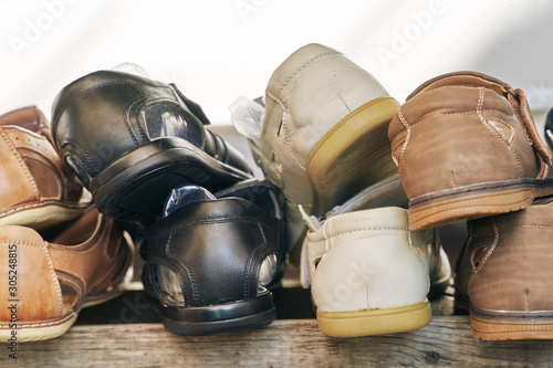 close-up of several men's shoes on a wooden shelf