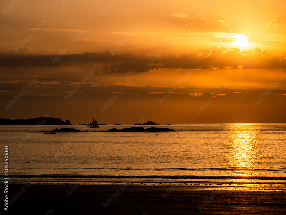Naklejka premium Dramatic orange sunset with clouds and sailing boat Horizontal seascape with sailboat silhouette.