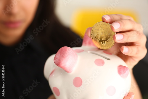 woman hold piggybank in arms put money into moneybox photo