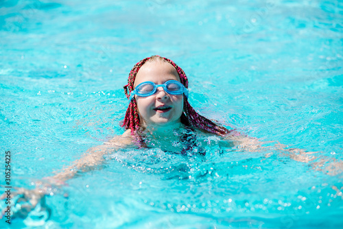 teenage girl in outdoor pool with safety glasses © sushytska