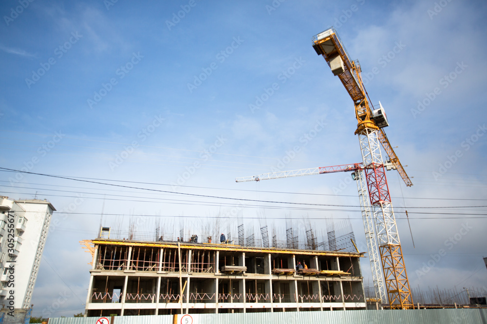 Background of construction site and building with big construction crane and blue sky.
