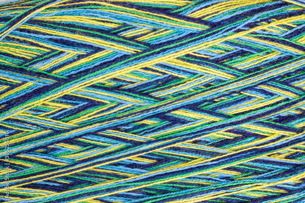 background of multicolored ball of wool in yellow, green and blue