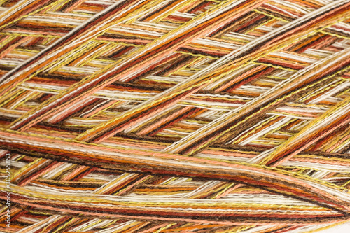 background of multicolored ball of wool in white, orange and brown