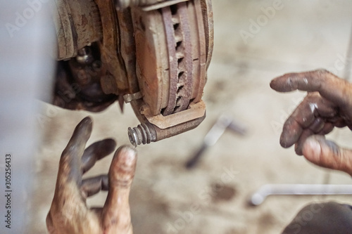 Closeup of a car mechanic's hand. Car brake replacing new caliper pin. car repair, suspension parts, garage repair. car brake system.